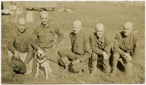 Five Soldiers Kneeling in Grass Posing for Picture with a Dog on a Leash